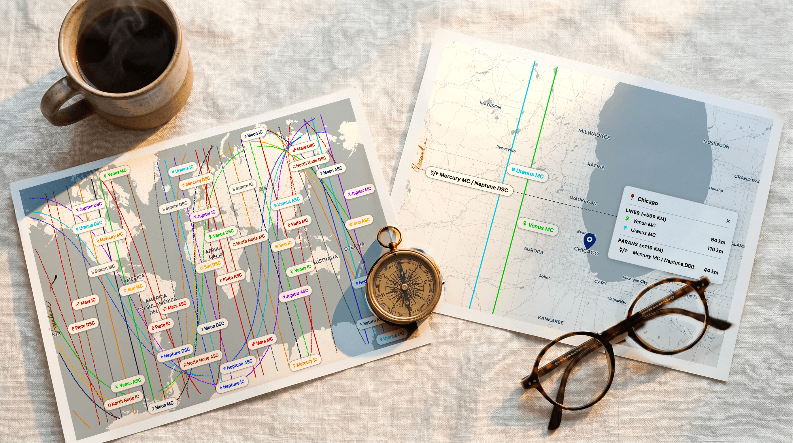 Two identical printed astrocartography maps side by side on warm linen with a brass compass between them, round tortoiseshell reading glasses on the edge, soft morning light in deep blue and warm gold tones